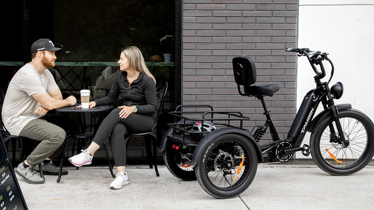 Couple en arrêt à un café avec leur Vélo électrique urbain Taubik