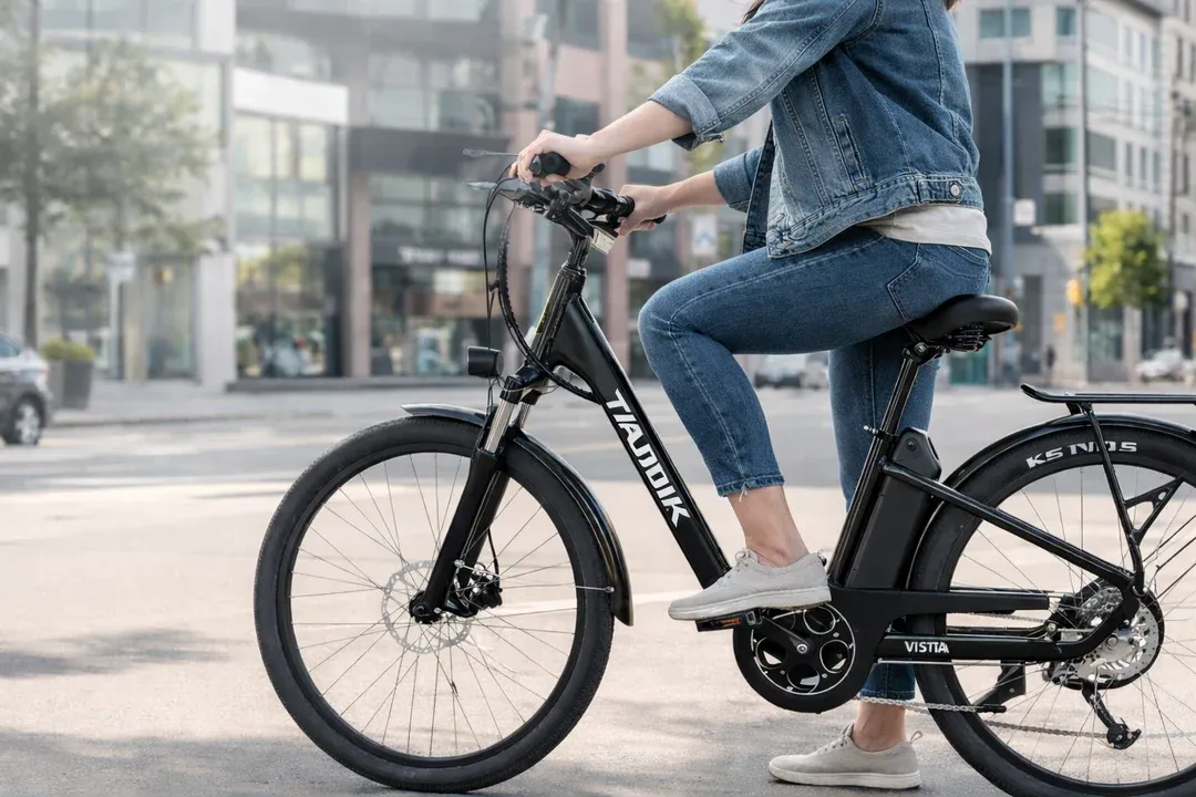 Cycliste sur un vélo électrique Taubik Vista 26 à cadre bas pour les déplacements quotidiens en ville.